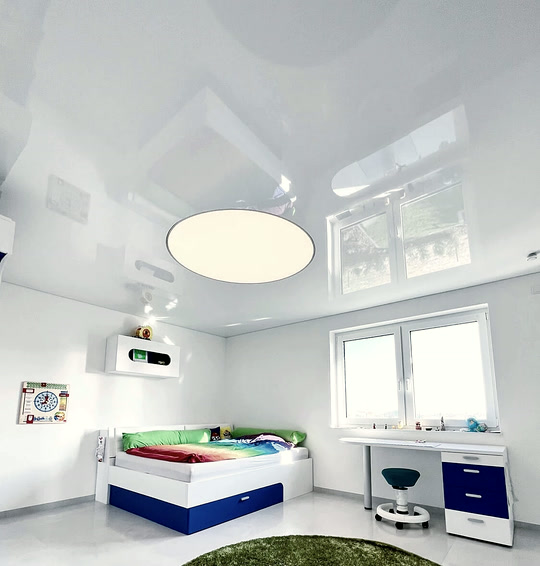 Kinderzimmer mit weißer Hochglanz-Spanndecke und einer runden, eingelassenen Leuchte
