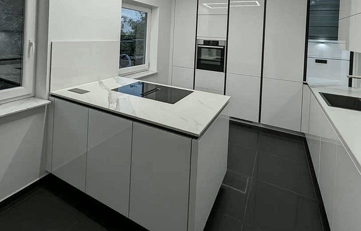 Küche mit weißer Spanndecke, Kücheninsel und einem leuchtenden Lichtrahmen in der Decke